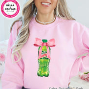 Pink sweatshirt featuring a graphic of a green soda bottle with a pink bow. The bottle has a green cap and the words 