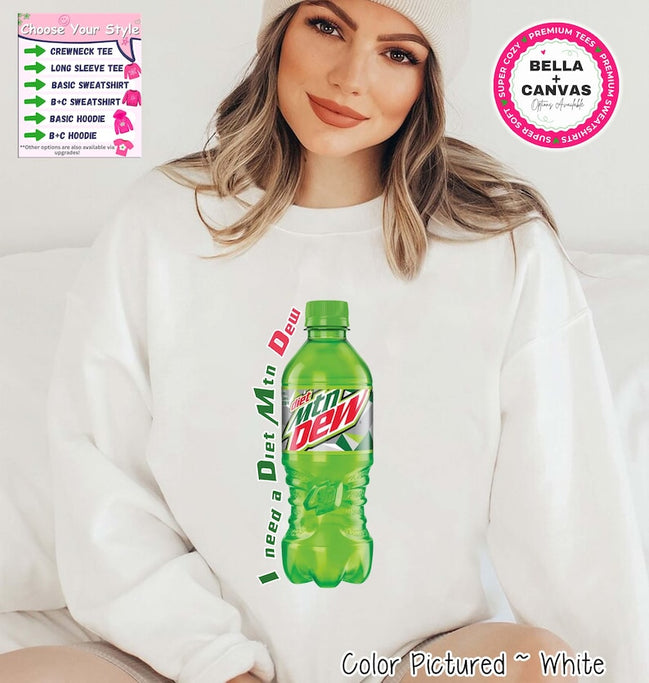 White sweatshirt with a green Diet Mtn Dew bottle graphic. The text "I need a Diet Mtn Dew" is printed on the left side of the bottle. The sweatshirt has a crew neck and long sleeves. The image also shows options for crewneck tee, long sleeve tee, basic sweatshirt, B+C sweatshirt, basic hoodie, and B+C hoodie.