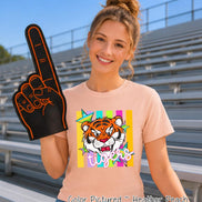 May include: A heather peach t-shirt featuring a graphic of a tiger face surrounded by colorful stars and vertical stripes. The word 