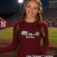 May include: A cardinal red long-sleeve shirt featuring a white graphic print of a soccer goal, a central bow, and a soccer ball connected by a swirling line, with the text 