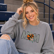 May include: A grey crewneck sweatshirt featuring the word MOM in a black and white checkered pattern. The letter O is replaced by an orange basketball graphic with black lines, accented by three multi-colored star shapes in blue, purple, and yellow.