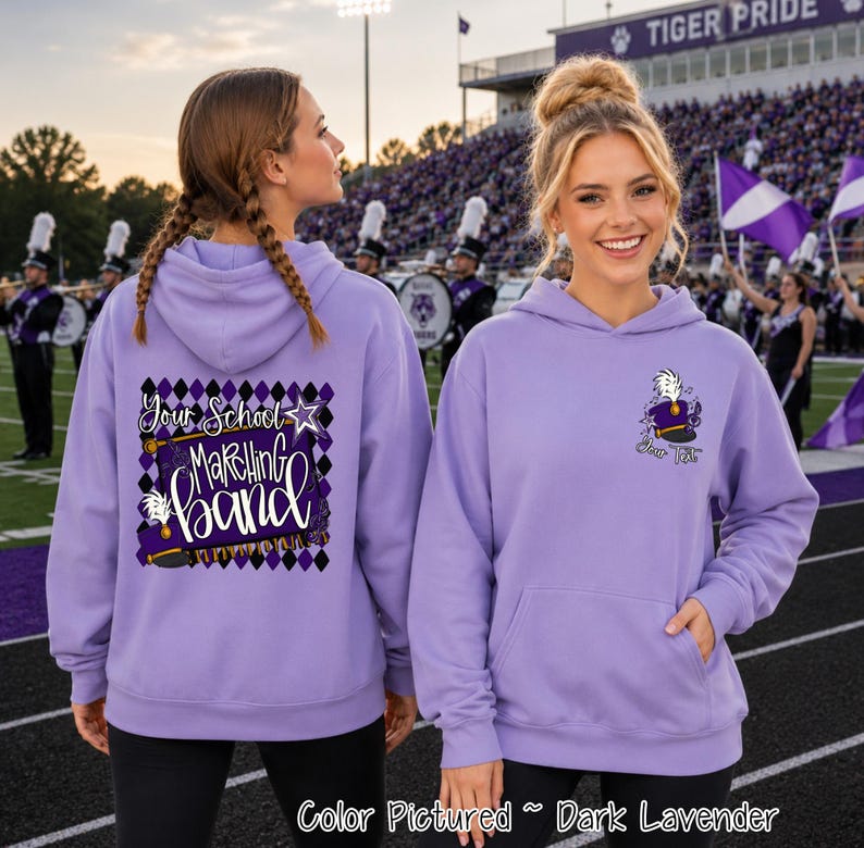 May include: A dark lavender hooded sweatshirt featuring a graphic on the back with a purple and black diamond pattern, a white star, and the text "Your School Marching band". The front left chest displays a small graphic of a marching band hat.