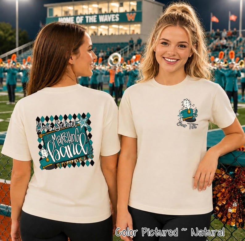 May include: A natural-colored t-shirt featuring a graphic design on the back and front. The back displays a teal marching band hat, a star, and the text 