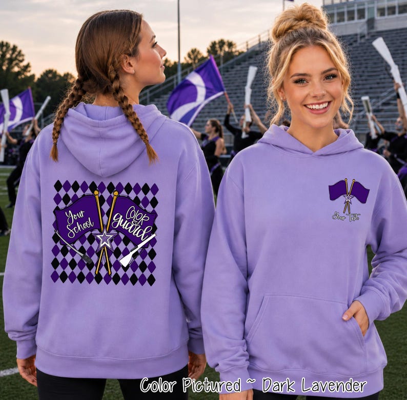 May include: A dark lavender hooded sweatshirt featuring a color guard graphic. The back displays a purple and black diamond pattern with two crossed flags labeled Your School and Color Guard. The front left chest shows a smaller crossed flag icon.