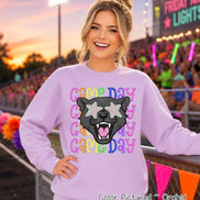 May include: A light purple crewneck sweatshirt featuring a graphic of a black panther head with star-shaped eyes. The text 