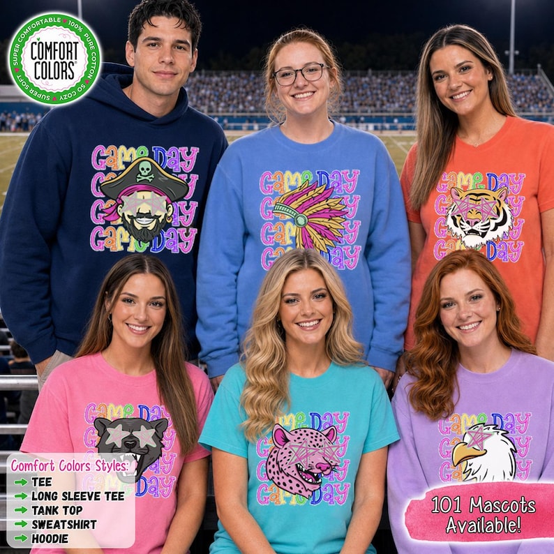 May include: A navy blue hoodie, a blue sweatshirt, and four t-shirts in orange, pink, teal, and lavender. Each garment features the text Game Day in a colorful, wavy font and a graphic of a mascot with star-shaped eyes, including a pirate, tiger, and eagle.