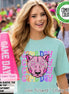 May include: A light mint green t-shirt featuring a graphic of a pink panther face wearing star-shaped glasses, surrounded by the repeating text Game Day in colorful, patterned letters. A bright pink megaphone with the text Game Day is held nearby.