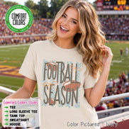 May include: An ivory short-sleeve t-shirt featuring a graphic print with the text 