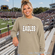 A long-sleeve khaki crewneck sweatshirt featuring a central hexagonal graphic. The graphic contains a camouflage pattern background with the word EAGLES printed in large, white, distressed-style block capital letters.