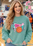 A seafoam green long-sleeve crewneck sweatshirt featuring a graphic design on the front. The design includes a white pennant flag with the text "GAME DAY" in pink, an orange basketball, a pink star, and a blue lightning bolt.