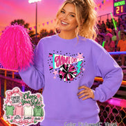 A violet long-sleeve sweatshirt featuring a graphic print with the text GAME DAY, a megaphone, a pom-pom, stars, and a lightning bolt. The design includes pink, white, and teal accents. A bright pink pom-pom is held to the side.
