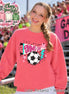 A watermelon-colored crewneck sweatshirt featuring a graphic print with the text GAME DAY in pink, a black and white soccer ball, a teal lightning bolt, and pink stars. The design is centered on the front of the long-sleeved garment.