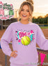 A light purple crewneck sweatshirt featuring a graphic print with a yellow softball, a teal and white pennant flag with the text "GAME DAY" in pink, and decorative pink stars, teal lightning bolts, and black polka dots.