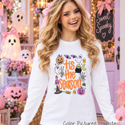 A white long-sleeve shirt featuring a colorful graphic print with the text 'tis the season' in orange. The design includes illustrations of a jack-o'-lantern, ghosts, a cauldron, a witch hat, a spider web, bats, and candy corn.