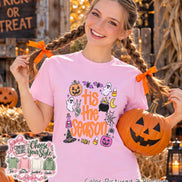 A light pink t-shirt featuring a graphic print with the text 'tis the season' in orange, surrounded by Halloween-themed illustrations including a pumpkin, ghosts, a cauldron, a spider web, a witch hat, and candy corn.